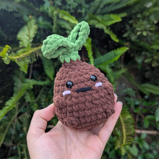 A plush garden sprout toy with dark brown body and light green leaf